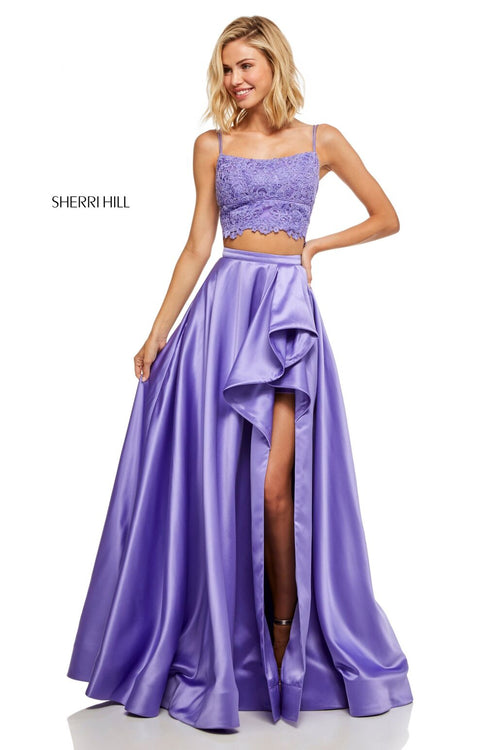 This Sherri Hill 52623 two-piece gown in lilac features a lace top and a satin skirt with a ruffle slit.