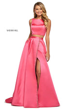 This Sherri Hill 53527 mikado two-piece gown in coral features a bateau neck bodice and a long wrap skirt with an embellished trim. 