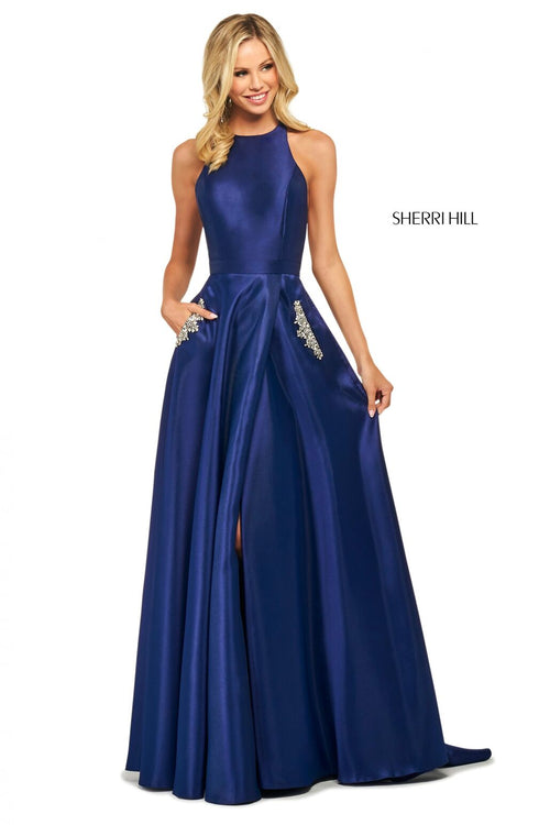 This Sherri Hill 53529 A-line satin gown in navy features a high cut halter style neckline and embellished skirt pockets. 